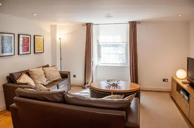 a living room with a couch and a table at CS Exclusive Apartments of Princess Street West End in Edinburgh
