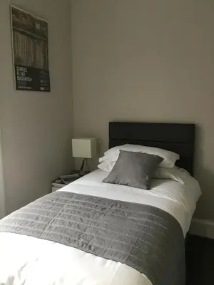 a bedroom with a large bed with a gray pillow at Amaryllis Guest House in Edinburgh