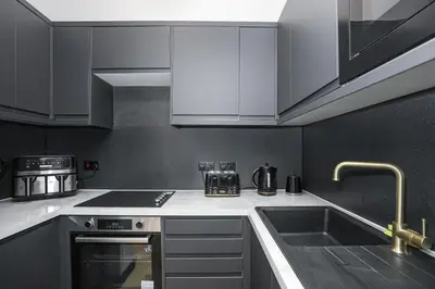 a kitchen with white cabinets and a sink at 1 Bedroom Gorgie Sleeps 4 Easy City Access in Edinburgh