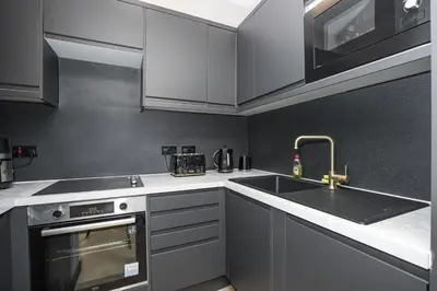 a kitchen with white cabinets and a sink at 1 Bedroom Gorgie Sleeps 4 Easy City Access in Edinburgh
