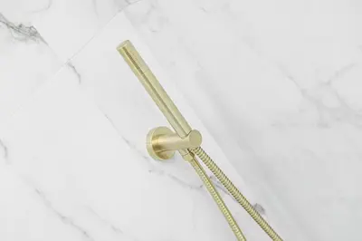 a shower with a gold shower head on a white wall at 1 Bedroom Gorgie Sleeps 4 Easy City Access in Edinburgh