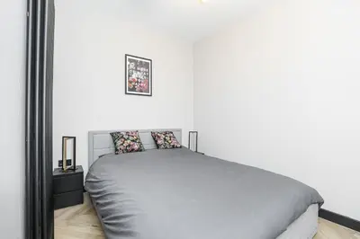 a bedroom with a bed and a white wall at 1 Bedroom Gorgie Sleeps 4 Easy City Access in Edinburgh