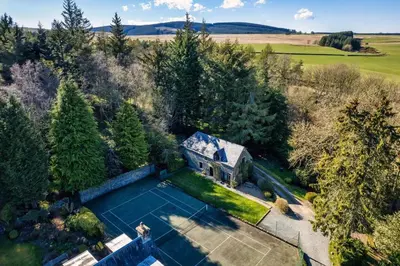 an aerial view of a house with a tennis court at Black Barony Home Farm Cottage in Eddleston