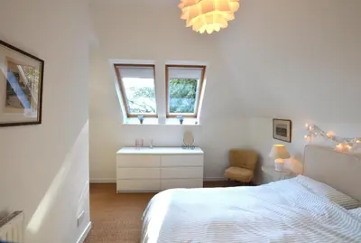 a white bedroom with a bed and a window at Black Barony Home Farm Cottage in Eddleston