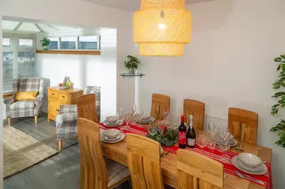 a dining room with a table with wine glasses at Tranquil Coastal Getaway Home in Saint Davids