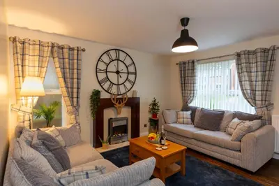 a living room with a large clock on the wall at Tranquil Coastal Getaway Home in Saint Davids