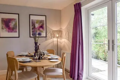 a dining room with a table with chairs and a window at Am Tighndhuin in Killin