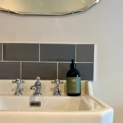 a bottle of wine sitting on a bathroom sink at Suie Hunting Lodge in Killin