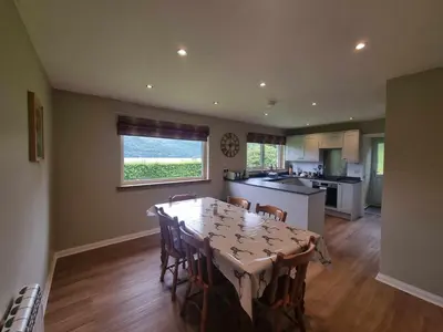 a kitchen and dining room with a table and chairs at Inveruglas Farm Cottage in Arrochar