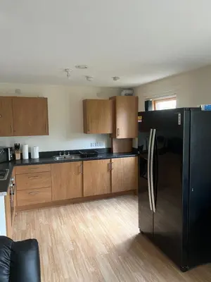 a kitchen with a black refrigerator and wooden cabinets at Riverview Retreat Shawlands in Mansewood