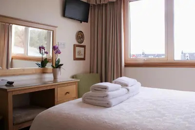 a hotel room with a bed with towels on it at Greencourt Guest House in Oban