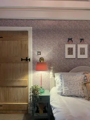 a bedroom with a bed and a door and a lamp at Clover Neuk - Hot Tub - Coorie Doon Stays in Fairlie