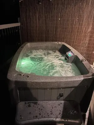 a bath tub with green water in it at Clover Neuk - Hot Tub - Coorie Doon Stays in Fairlie