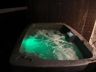 a jacuzzi tub with a cell phone in it at Clover Neuk - Hot Tub - Coorie Doon Stays in Fairlie