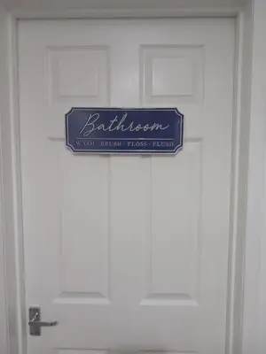 a blue sign on the door of a white door at Douglas Apartment - Trains to Edin & Glasgow - Private Parking in Airdrie