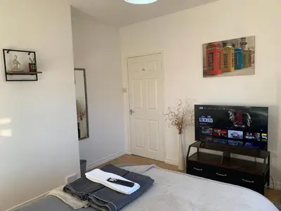 a bedroom with a bed and a flat screen tv at Douglas Apartment - Trains to Edin & Glasgow - Private Parking in Airdrie