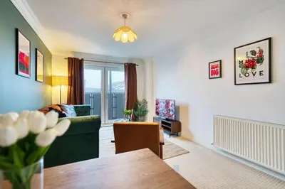 a living room with a green couch and a table at 2BR Flat Central Location with Free Parking in Glasgow