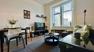 a living room with a couch and a table at Bright and spacious apartment near Glasgow in Dalmuir