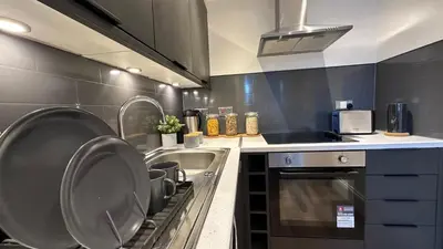 a kitchen with a sink and a stove at Bright and spacious apartment near Glasgow in Dalmuir