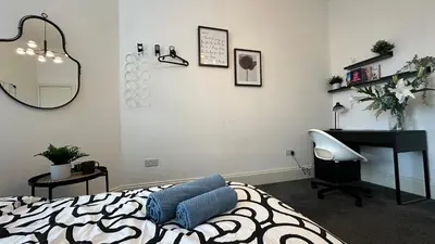 a bedroom with a bed and a desk and a chair at Bright and spacious apartment near Glasgow in Dalmuir