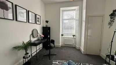 a room with a desk and a chair and a window at Bright and spacious apartment near Glasgow in Dalmuir