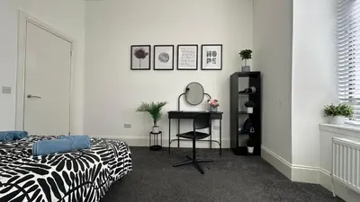 a bedroom with a bed and a mirror and a desk at Bright and spacious apartment near Glasgow in Dalmuir