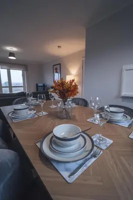 a dining room table with plates and wine glasses at Franklin Place in East Kilbride