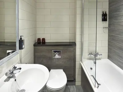 a bathroom with a toilet and a sink and a tub at Village Hotel Glasgow in Glasgow