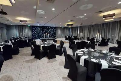 a banquet hall with tables and chairs in a room at Village Hotel Glasgow in Glasgow