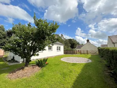 a white house with a tree in the yard at Beautiful Cottage in Historical Robert Burns Farm - Pass the Keys in Dumfries