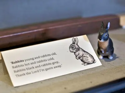 a figurine of a rabbit sitting next to a sign at Beautiful Cottage in Historical Robert Burns Farm - Pass the Keys in Dumfries