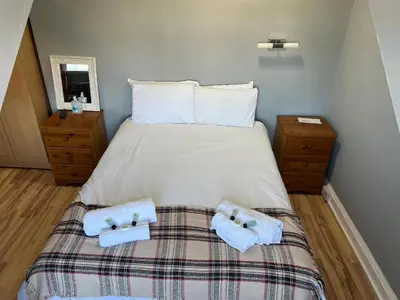 a bedroom with a bed with two towels on it at Gothenburg Hotel in Rosyth
