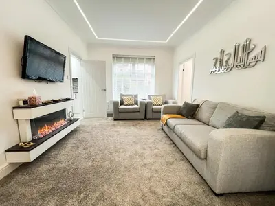 a living room with a couch and a fireplace at Stylish Modern Glasgow Home with Excellent Value in Glasgow