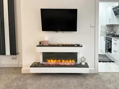 a living room with a fireplace with a tv above it at Stylish Modern Glasgow Home with Excellent Value in Glasgow