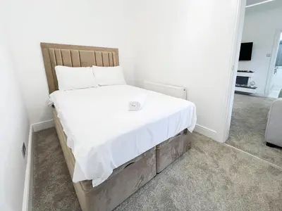 a bed with white sheets and pillows in a room at Stylish Modern Glasgow Home with Excellent Value in Glasgow