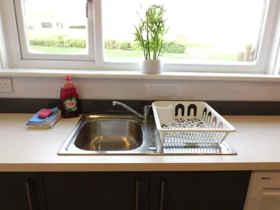 a kitchen sink with a dish drying rack next to a window at 4 Bedroom Newly Refurbished Home in East Kilbride in East Kilbride