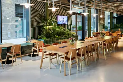 a restaurant with wooden tables and chairs and plants at The Social Hub Glasgow Extended Stay in Glasgow