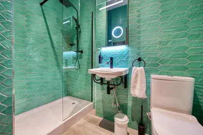 a green tiled bathroom with a sink and a shower at Grand Central Station 2 Bed Apartment A1 in Glasgow