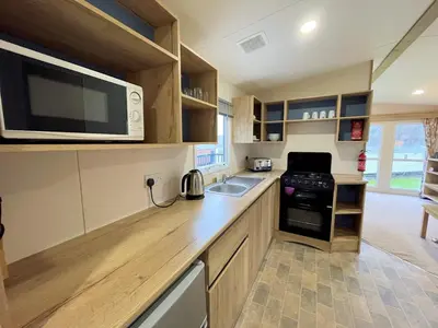 a kitchen with a counter with a microwave and a sink at Cosy 3BR Getaway in Beautiful Country Park - Pass the Keys in Beattock