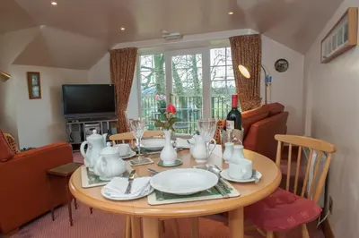 a dining room table with plates and glasses on it at Loaninghead Holidays in Drymen