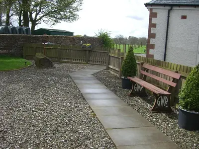 a wooden bench sitting next to a wooden fence at Loaninghead Holidays in Drymen