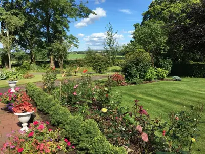 a garden with colorful flowers and a lawn at Loaninghead Holidays in Drymen