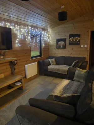 a living room with a couch and a tv at Lomond Lodge Rowardennnan in Rowardennan