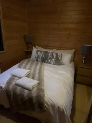 a bedroom with a bed with two towels on it at Lomond Lodge Rowardennnan in Rowardennan