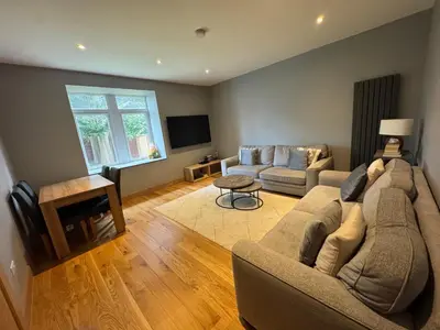 a living room with a couch and a tv at The Barn in Hawkhead