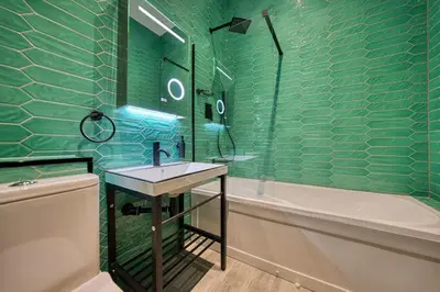 a green tiled bathroom with a sink and a tub at Spacious Central Station 2 Bed Apartment B3 in Glasgow