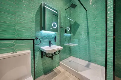 a green tiled bathroom with a sink and a shower at Stunning Central Station 2 Bed Apartment B4 in Glasgow