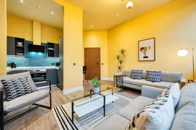 a living room with two couches and a kitchen at Stunning Central Station 2 Bed Apartment B4 in Glasgow