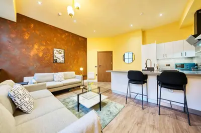 a living room with a couch and a kitchen at Grand Central Station 1 Bed Apartment A5 in Glasgow