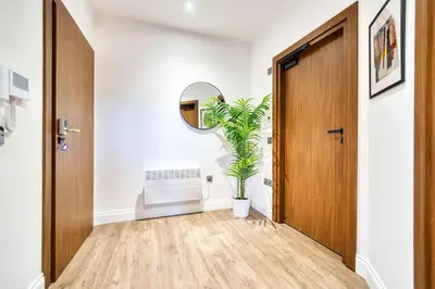 a hallway with a door and a potted plant at Lovely Central Station 1 Bed Apartment A6 in Glasgow